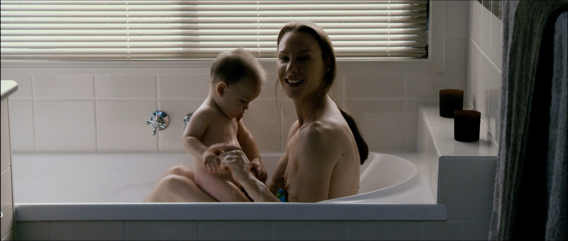 Belinda McClory is on a bathtub topless with little kid. 