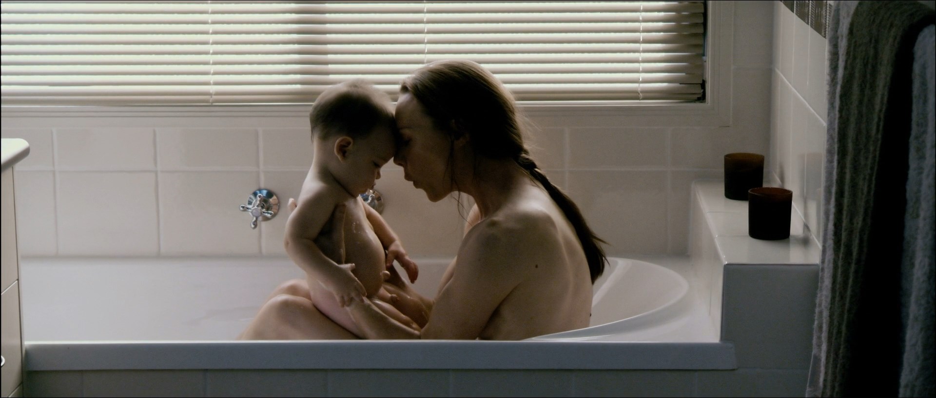 Belinda McClory is on a bathtub topless with little kid. 