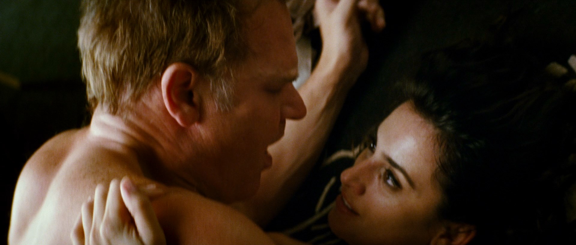 Topless Penelope Cruz is laying on the bed. 