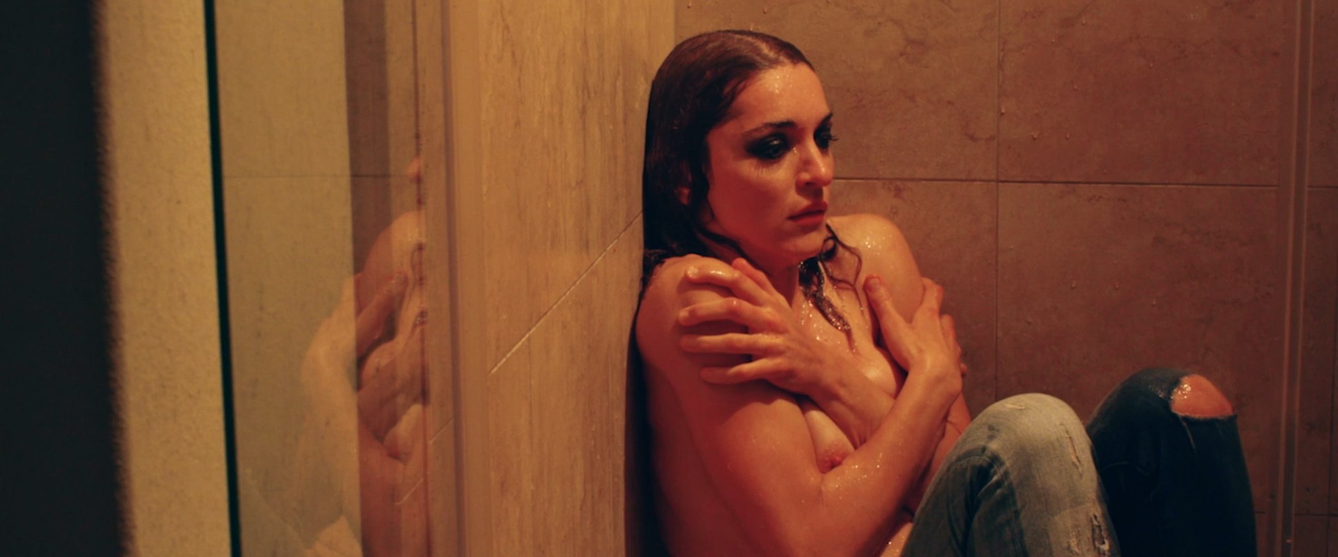 Youlika Skafida is in the shower topless and bloodied.
