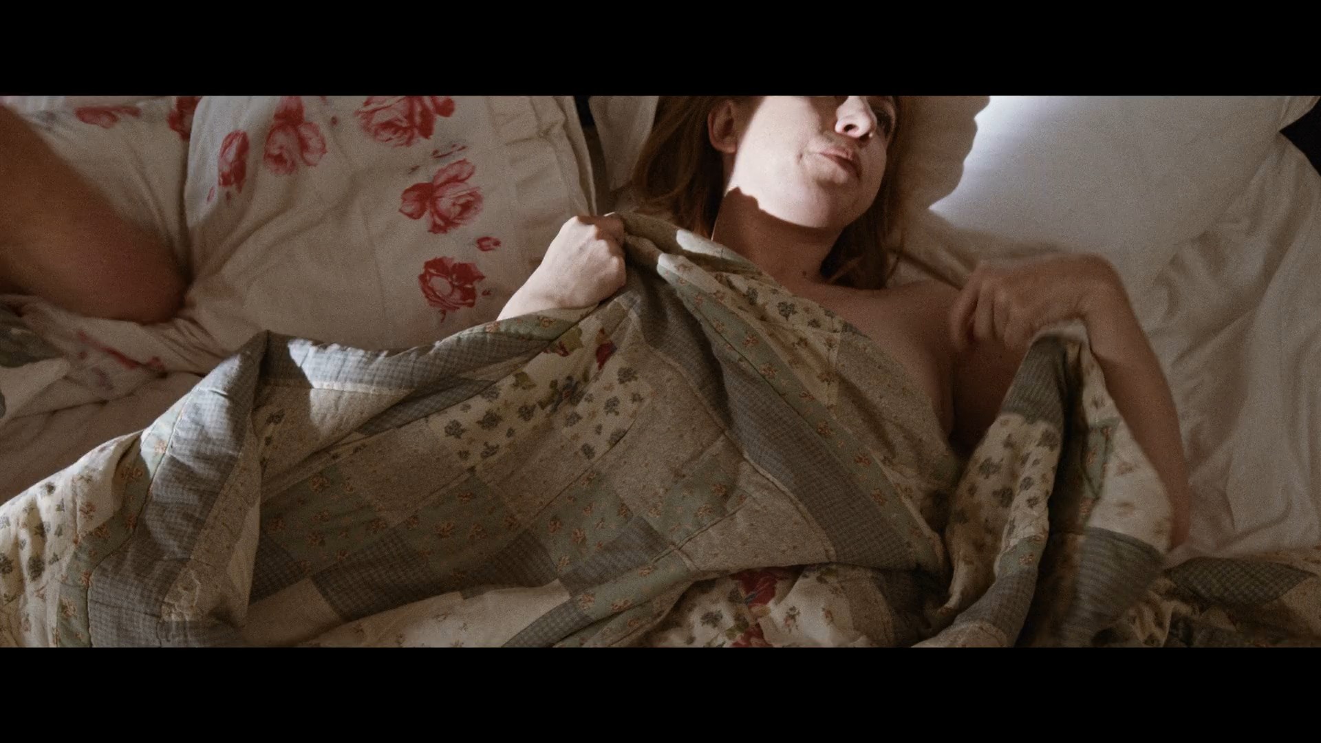 Victoria Smurfit briefly shows her tits when she is laying on the bed.
