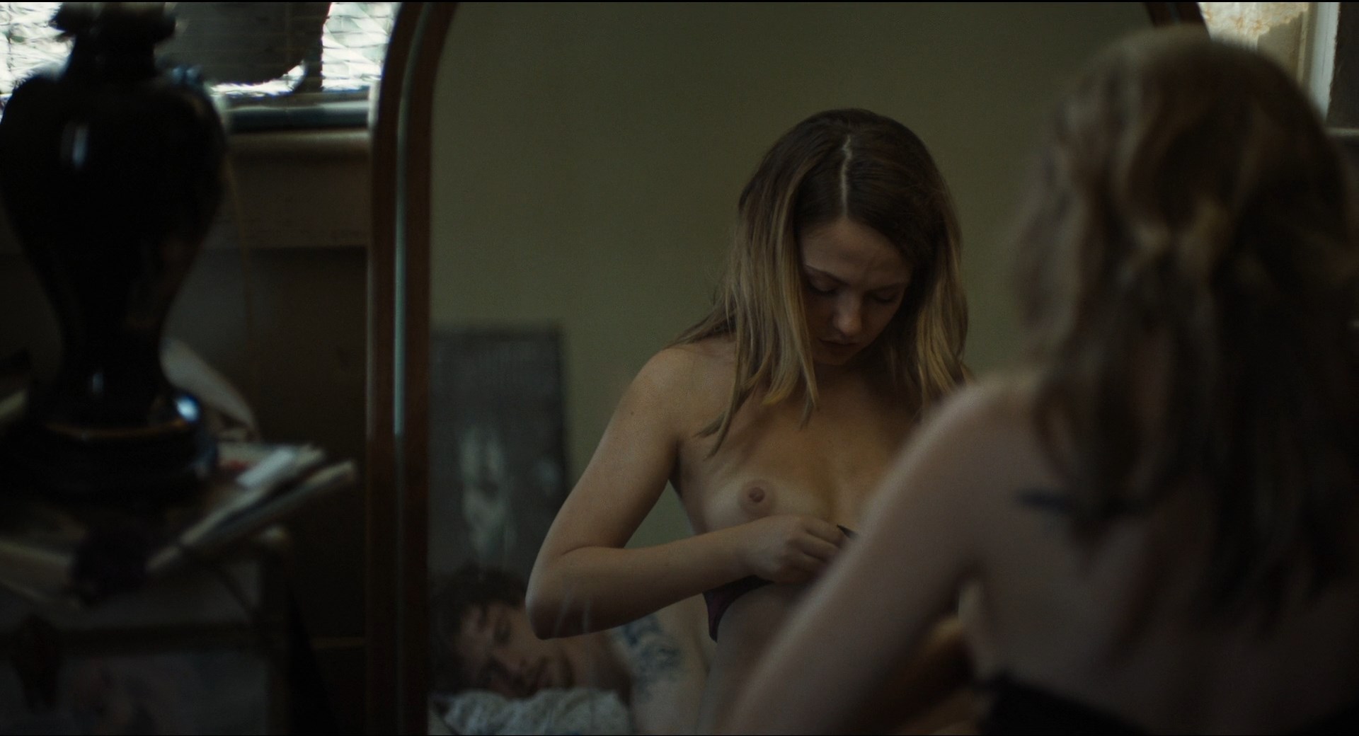 Emily Meade shows her tits while putting on a bra.
