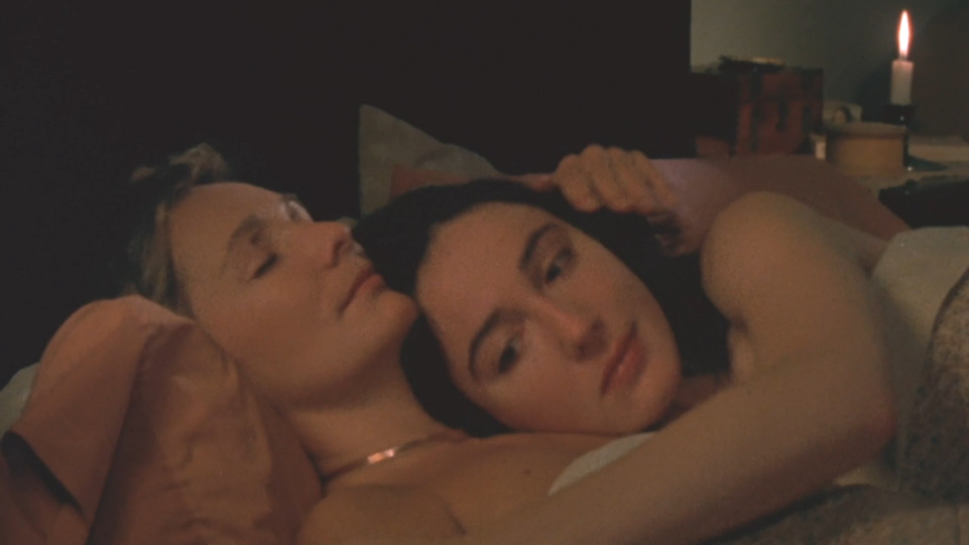 Linda Griffiths and Jane Hallaren are laying naked on the bed and chatting.