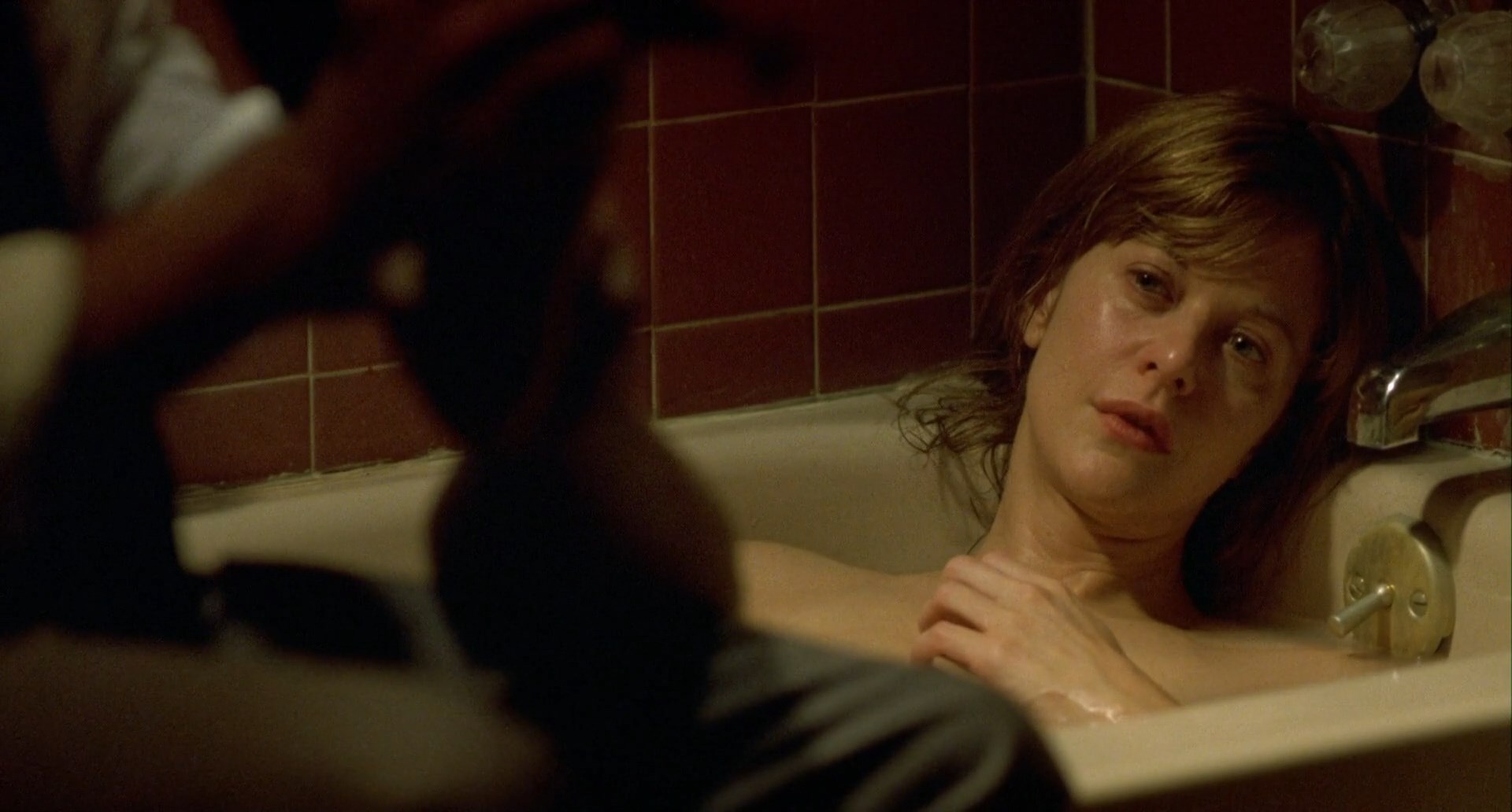 Topless Meg Ryan is sitting on a tub.
