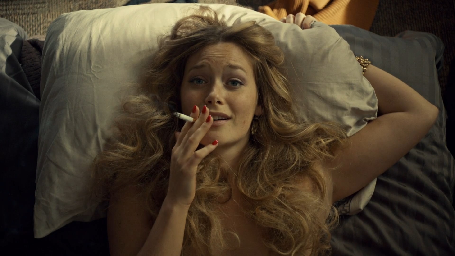 Rachel Keller is laying naked on a bed. 